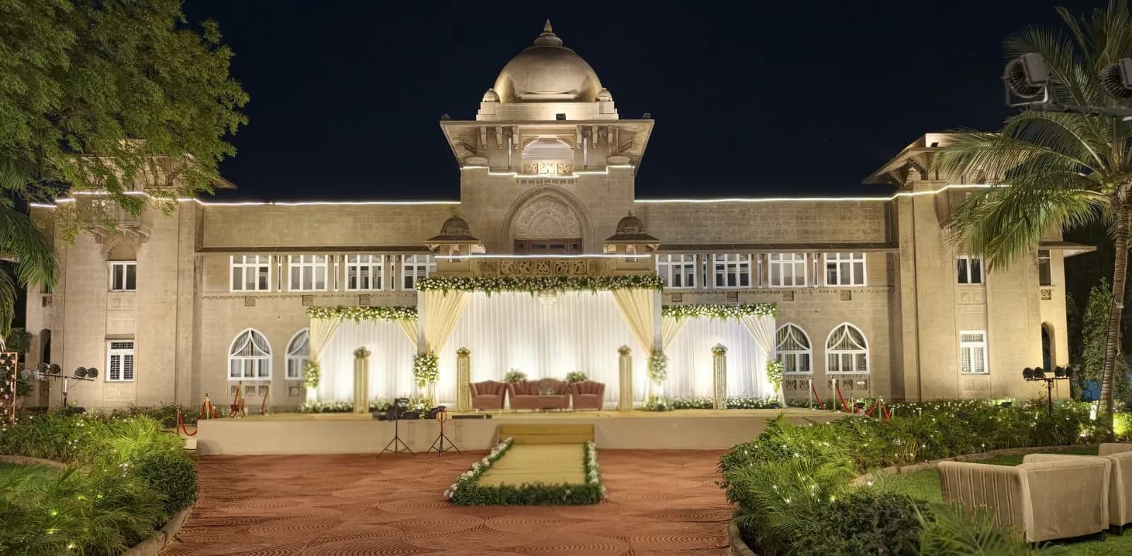 Reception stage with white drapes and pillars at Shivmahal Palace, Vadodara