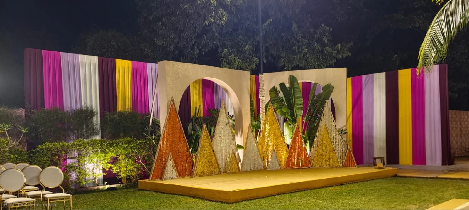 Sangeet stage with coloured drapes and marigold panels at Shivmahal Palace