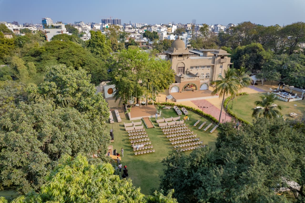 A Vadodara party plot set for a wedding: open lawn, guest seating and stage